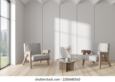 White Living Room Interior With Two Armchairs On Hardwood Floor. Meeting Corner With Books, Panoramic Window On Countryside. Copy Space Empty Wall. 3D Rendering