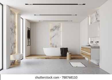 White and marble bathroom interior with a white tub standing on a wooden floor near a chair with self care products. 3d rendering mock up
