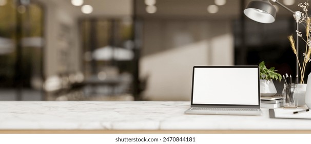 A white marble tabletop features a white-screen laptop computer and decorative objects with a blurred background of a modern office corridor. 3d render, 3d illustration