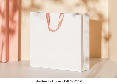 White paper bag with pink handles on a beige background with curtains. Mock up. 3d rendering