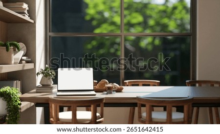 White screen laptop aside breads on plate and coffee on wooden table in a dining room or living room with garden view, 3D Rendering, 3D Illustration.