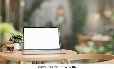 A white-screen laptop computer mockup is placed on a wooden table in a green comfortable cafe on a sunny day, accompanied by a coffee cup and a potted plant. 3d render, 3d illustration - Powered by Shutterstock