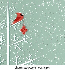 Winter background with red cardinal holding Christmas decoration