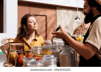 Woman shopping in zero waste grocery store, looking at bulk products in reusable packaging while being assisted by smiling seller. Customer in local neighborhood shop receiving free. 3D Illustration - Powered by Shutterstock