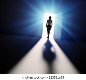 A Woman Walking Into The Light Through Open Door