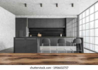 Wooden Desk Foreground And Blurred Background Of Black And Marble Minimalist Kitchen, Front View. Cutting Table In Grey Modern Kitchen, 3D Rendering No People