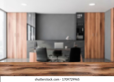 Wooden table for your product in blurry luxury CEO office with gray walls, tiled floor, computer table with chairs for visitors and bookcases with folders. Concept of advertising. 3d rendering