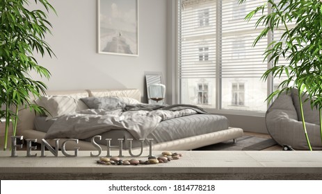 Wooden vintage table shelf with pebble balance and 3d letters making the word feng shui over blurred modern bedroom with big window and double bed, zen concept interior design, 3d illustration