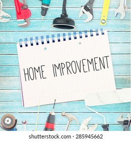 The Word Home Improvement Against Tools And Notepad On Wooden Background