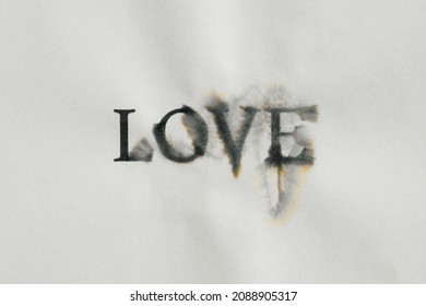 Word " LOVE " is written on a paper crumpled background with ink drips on paper. Concept of conflict, spoiled relationship or loneliness.	