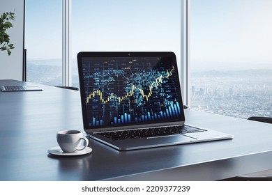 workplace with creative forex chart with candlestick graph, index and tech hologram on laptop screen, coffee cup on office background with window and blurry city view. Trade, stock