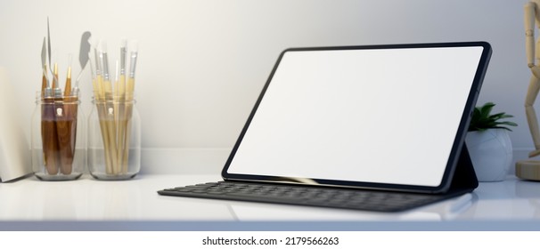 Workspace Tabletop With Portable Tablet Touchpad White Screen Mockup, Wireless Keyboard And Painting Tools Over White Wall. Close-up. 3d Rendering, 3d Illustration