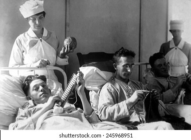 Wounded American Veterans of WWI. Nurses are assisting bed-ridden wounded in knitting. Walter Reed Hospital, Washington, D.C. Ca. 1918-19.