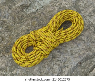 Yellow Climbing Rope On A Stone, 3d Render