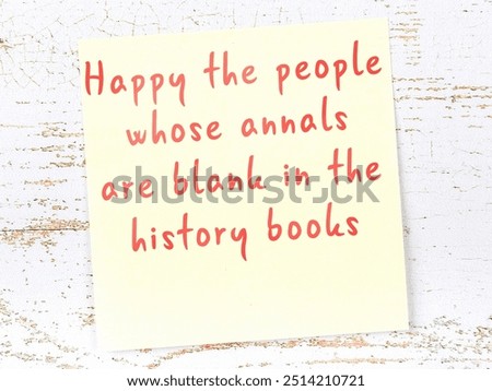 Yellow sticky note with smart quotation handwritten on it hanging on wooden wall