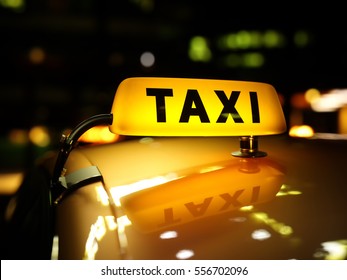 Yellow taxi sign at night. Taxi car on the street at night. Taxi car roof sign on bokeh background