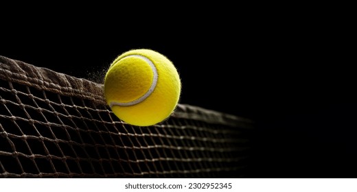 Yellow tennis ball flying into the tennis net on black background. Banner with free space for text. - Powered by Shutterstock