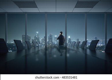 Young businessman talking on phone in conference room interior with table, chairs and night city view. 3D Rendering - Powered by Shutterstock