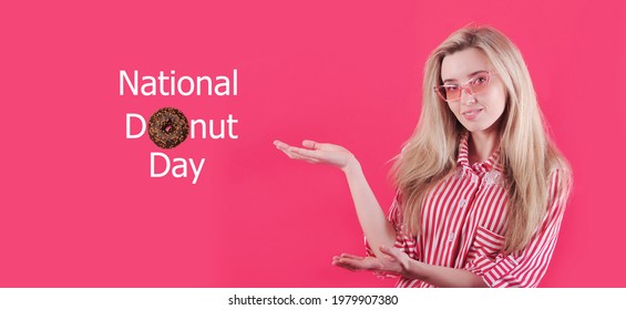 Young woman points with her hands to the inscription national donut day on pink background. - Powered by Shutterstock