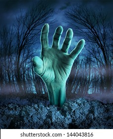 Zombie hand rising out of the ground in a spooky dark forest with creepy trees and fog as a symbol of Halloween imagination with a dangerous monster coming back from the dead.