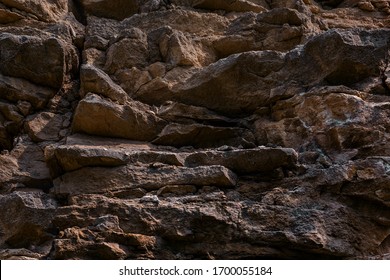 Dark texture cut blocks trench. Mining cliff of rough rock crash surface. Coarse detail quarry backdrop. Heavy grunge damage natural wall cave. Crack antique medieval marble front facade for design 3d - Shutterstock ID 1700055184