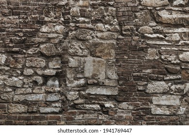 Old grungy retro grimy brick wall of ancient city. Uneven dirty pitted peeled surface brickwork of cellar worn. Ruined solid bumpy stiff blocks. Hard messy ragged holes brickwall for 3D grunge design