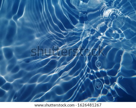 The rough​ pattern​ of surface​ blue​ water​ in​ the​ deep​ocean. The metal​ texture​ of surface​ blue​ water​ reflected​ by​ sunlight​ for​ background​