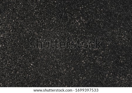 Black granite gravel, chipped flat little stones. Smooth small marble pebbles for paper web site texture backdrop. Rough natural quartz crumbs on concrete panel. Cement wall border outdoor city patio