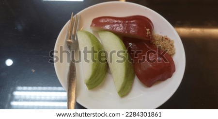Close​ up​ Guava​ and​ Rose​ a​pple​ pieces​ on​ small​ white​ ceramic​ dish​