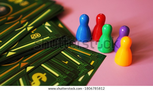 01-09-2020\
Minsk,Belarus Board game Monopoly with money and plastic chips. No\
logos or visible brands - pink\
background