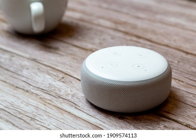 02-04-2021 Portsmouth, Hampshire, UK An Amazon Echo Dot Or Amazon Alexa Device Isolated On A Wooden Table Or Desk