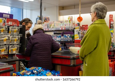 02/05/2020 Chichester, West Sussex, UK Shoppers Queuing At The Checkout Of A Supermarket Putting Produce On The Conveyor Belt