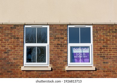 02-28-2021 Portsmouth, Hampshire, UK An Estate Agent Sold Sign In The Window Of New Apartments Or Flats