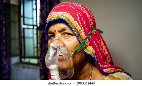 03 May 2021- Reengus, Sikar, India. Woman Suffering From Covid 19 Disease. Old Woman Admitted In Hospital And Inhaling Emergency Oxygen With Canula Mask.