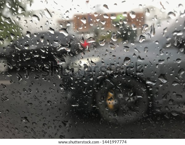 03-07-2019 : Bangkok, Thailand. The drop\
of water on the mirror car. The traffic jam because it’s rainy in\
the morning. You can see through to another\
car.