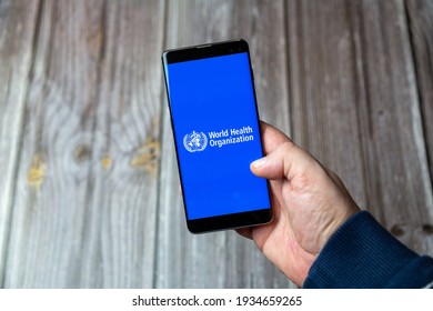 03-10-2021 Portsmouth, Hampshire, UK A Mobile Phone Or Cell Phone Being Held In A Hand With The World Health Organization App Open On Screen