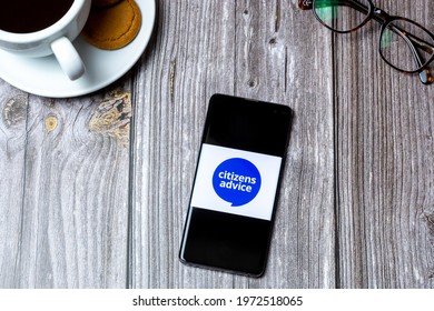 03-10-2021 Portsmouth, Hampshire, UK A Mobile Phone Or Cell Phone Laid On A Wooden Table With The Citizens Advice Bureau Logo On Screen