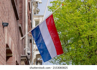 04 May every year, Remembrance of the Dead (Nationale Dodenherdenking) National flag of the Netherlands with half-mast, Memorial to victims of the world war two, Dutch flag hanging outside building.