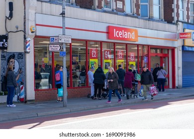 04/01/2020 Portsmouth, Hampshire, UK People Standing Two Meters Apart Or Social Distancing Whilst Queuing To Buy Food At An Iceland Supermarket