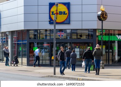 04/01/2020 Portsmouth, Hampshire, UK Shopper Queuing Outside A Lidl Supermarket Standing Two Meters Apart During The Covid-19 Or Coronavirus Pandemic