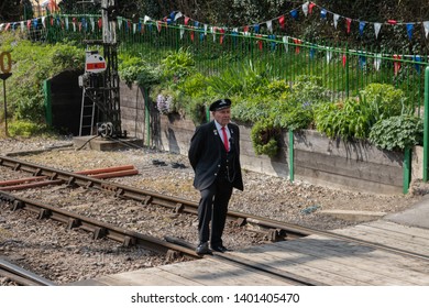 04/16/19 Ropley, Hampshire, UK A Train Conductor Stood On The Railway Tracks At A Vintage Railways Station 