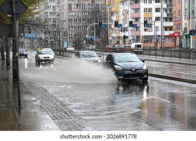 05.05.2021 wroclaw, poland, During a downpour, the car falls into a pool of water on the road, causing a splash.