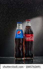 05/08/2020. Voronezh, Russia. Misted glass bottles of Pepsi and Coca-Cola on a dark background with splashing water.