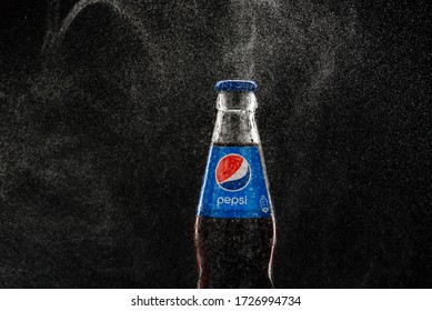 05/08/2020. Voronezh, Russia. Misted Pepsi bottle on a black background among splashes of water close-up.