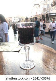 LVİV - UKRAİNE - 05.09.2020.cherry Liqueur Cocktail In The City Square Outdoors Served In Crystal Glass Tumbler On Wooden Table Unfilled City View In The Background People Lifestyle Vacation Travel. 