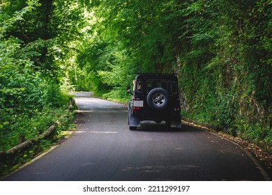 06 -14-2022 Lagos De Covadonga, Asturias, Spain: Off-road Black Car Driving On A Mountain Road Through A Forest.