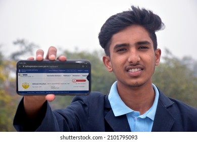 06-01-2022, Dewas, Madhya Pradesh, India. 15 Year Old School Boy Showing Covid Vaccination On Smart Phone In India, Sky Background