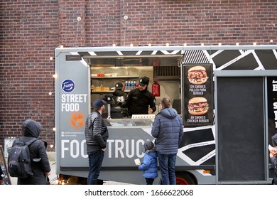 06-03-2020 Riga, Latvia Street Sale And People Concept - Happy Young Saleswoman At Food Truck Serving Male Customer.