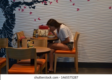 Cancún/Mexico- 06/29/2019: A Young Lady Quickly Eats Lunch Before A Flight At  Cancún International Airport