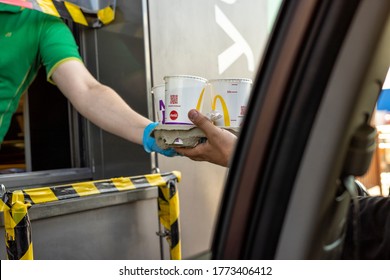 06/29/2020 Moscow, Russia A McDonald's Employee In Disposable Gloves Passes The Order To The Driver Through The Delivery Window